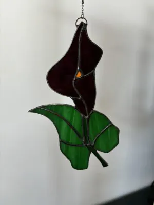 Glas in lood hanger: een paarse lelie met een groen blad.