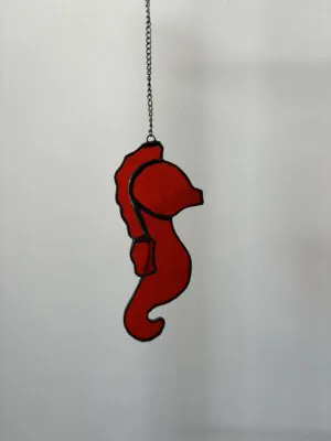 Glas in lood hanger: een rood zeepaardje.