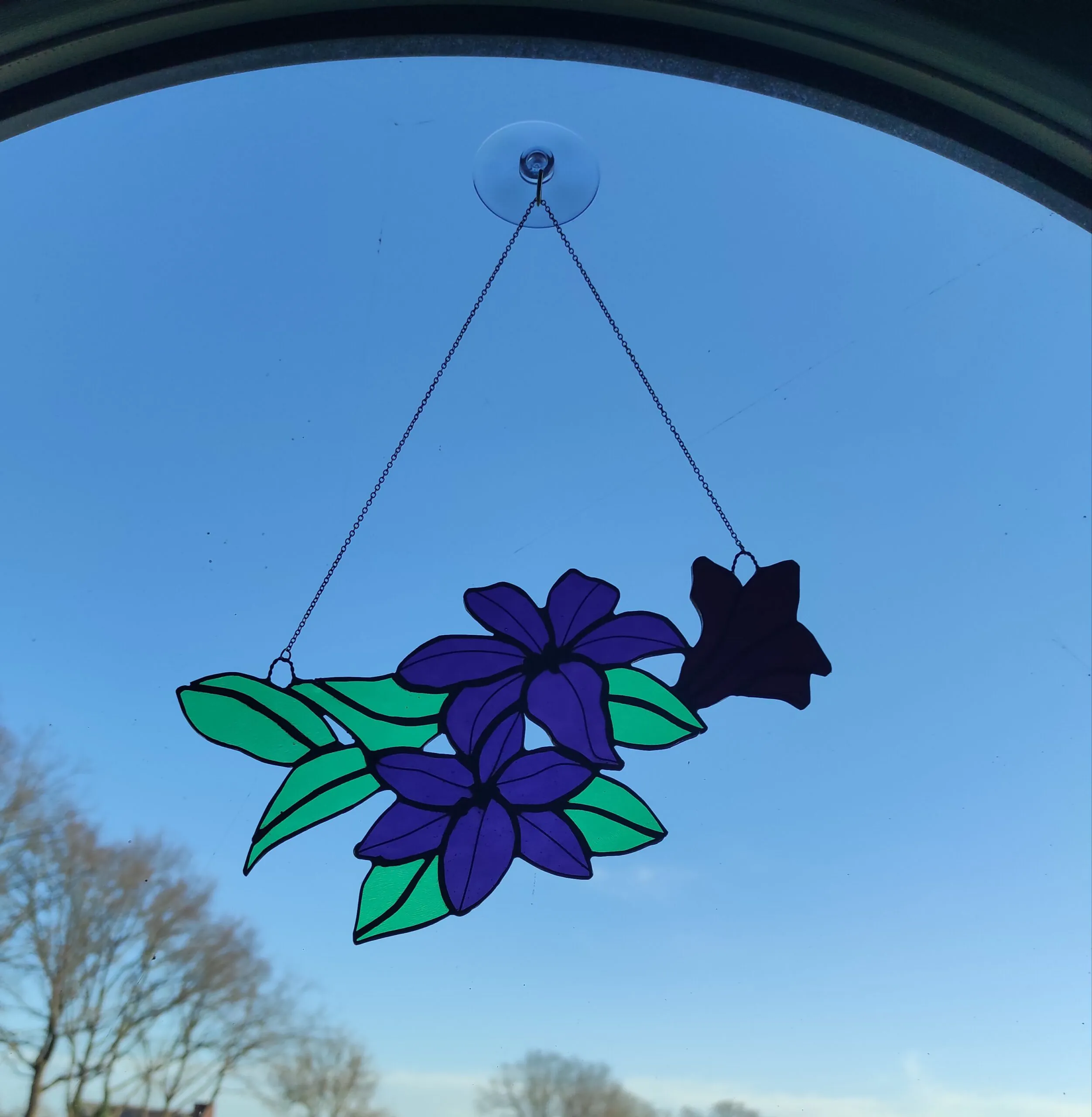 Glas in lood hanger: een hanger met paarse orchideeën en groene blaadjes.