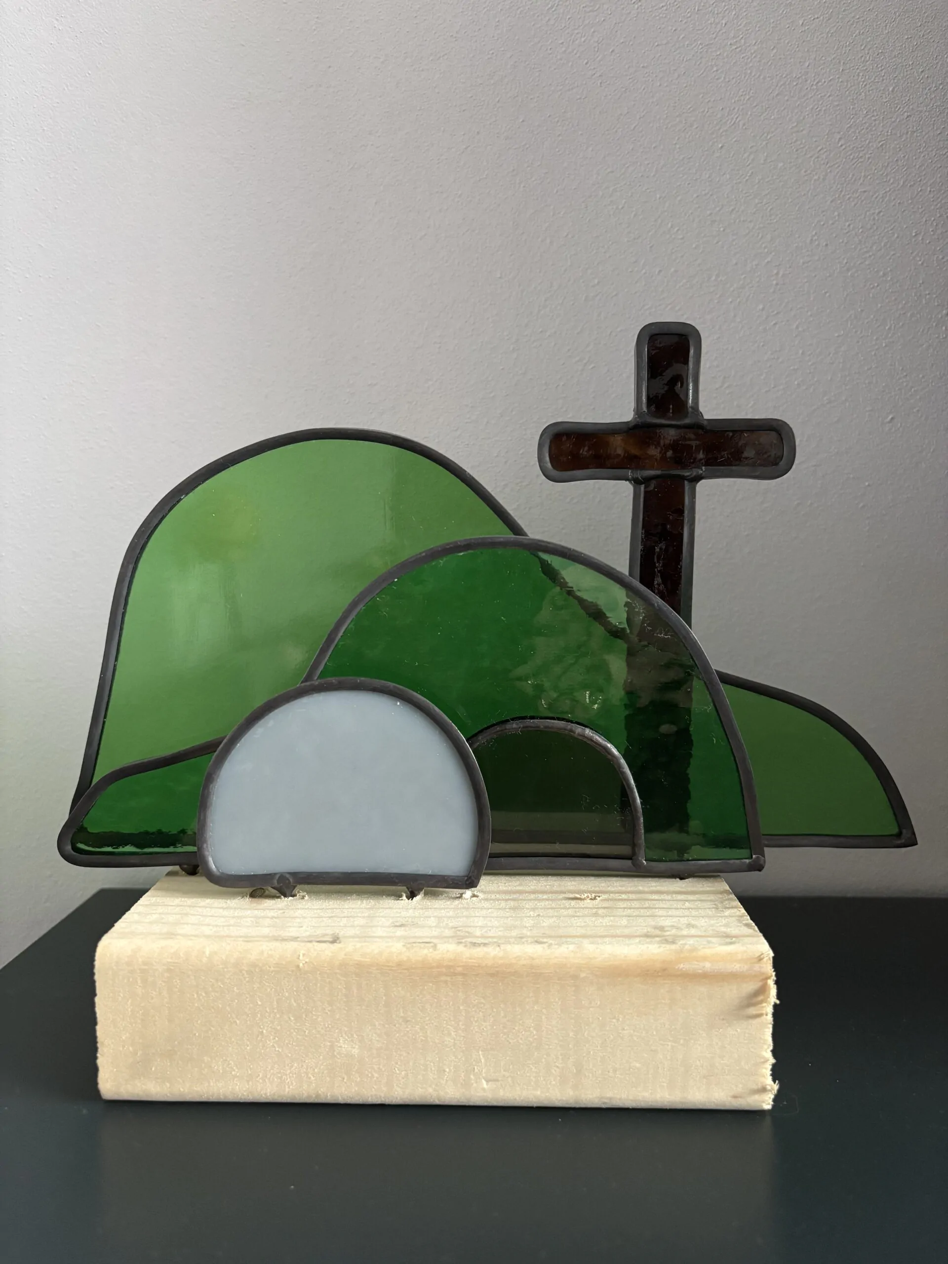Glas in lood glaswerk: een Paasscène met het open graf, de steen en het kruis.