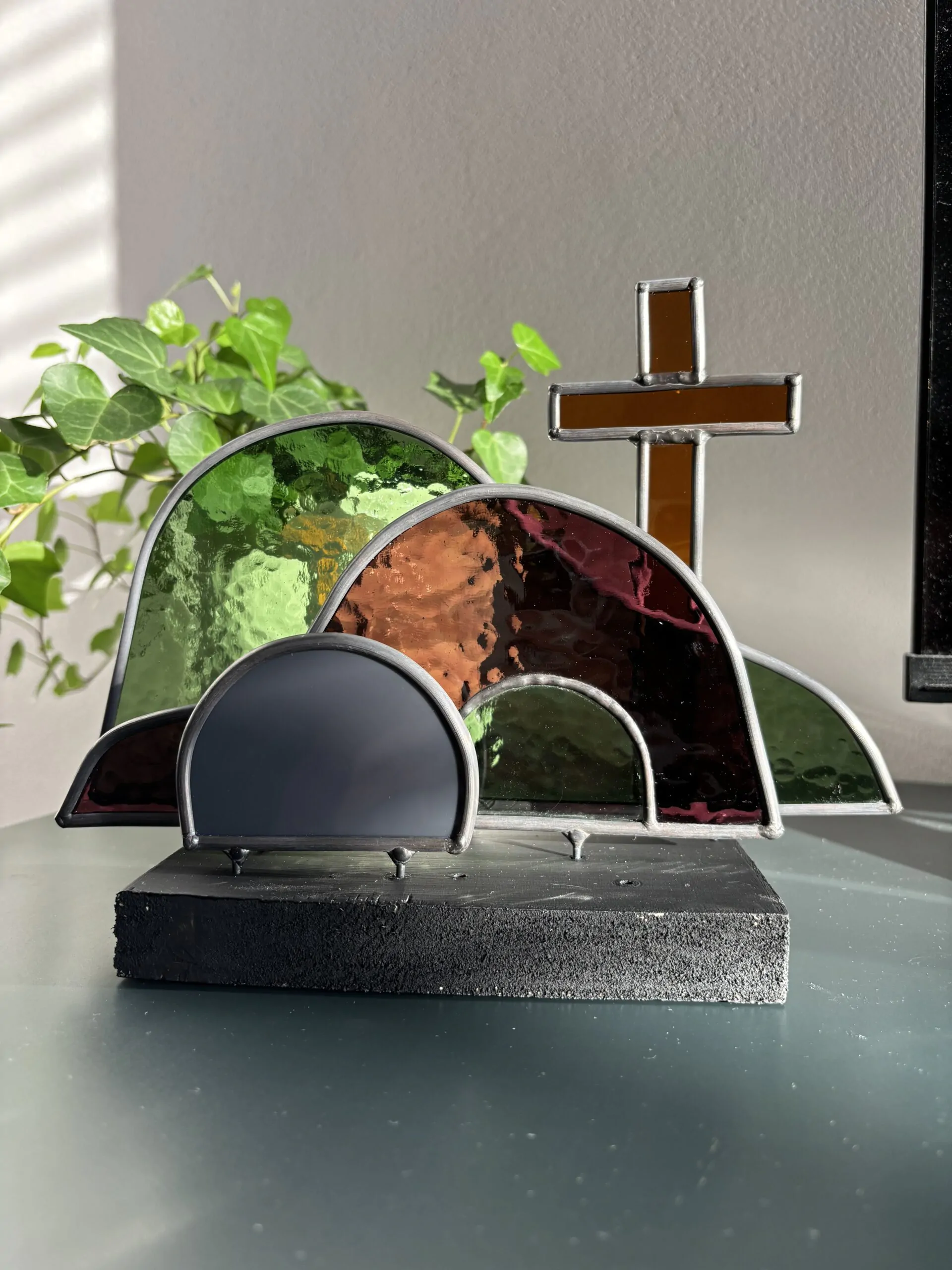 Glas in lood glaswerk: een Paasscène met het open graf, de steen en het kruis.