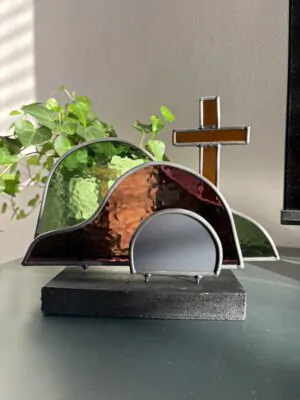 Glas in lood glaswerk: een Paasscène met het gesloten graf, de steen en het kruis.