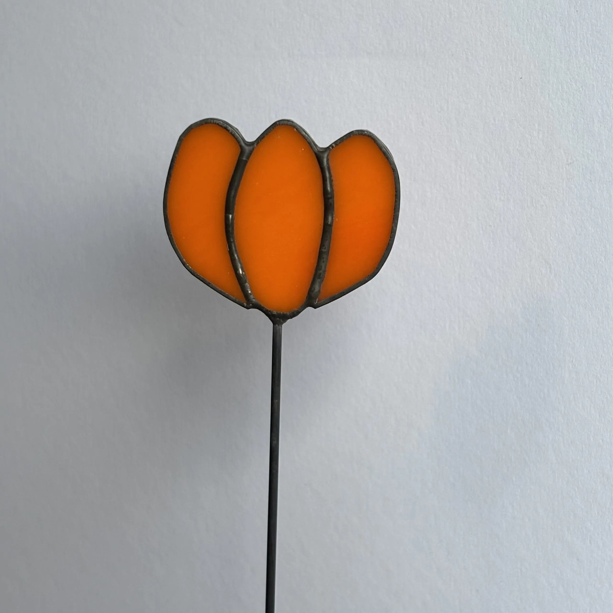 Tiffany glaskunst: een oranje tulp op een steel.