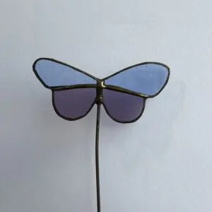 Tiffany glaskunst: een licht blauw met paarse vlinder op een steel.