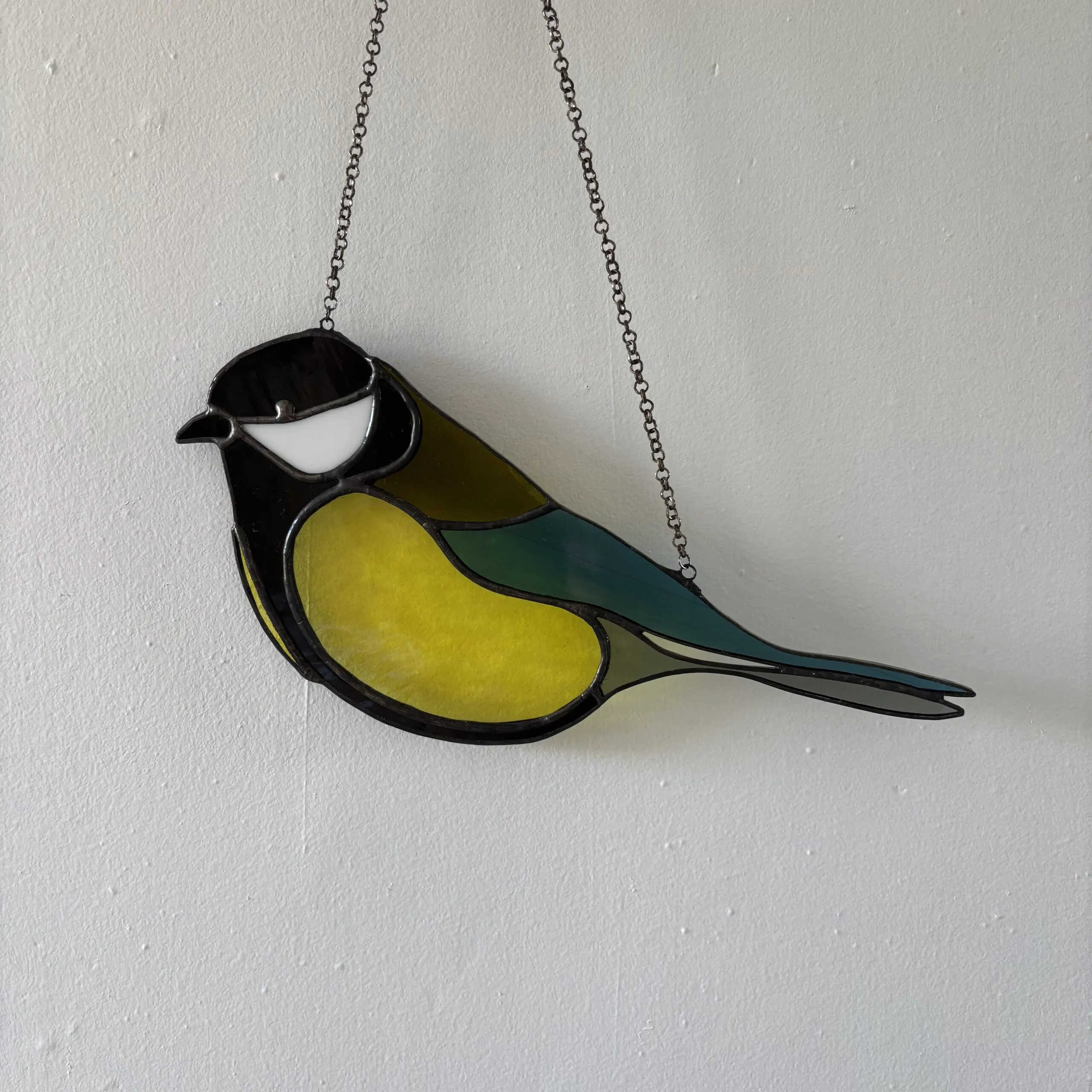 Glas in lood hanger: een koolmees gemaakt met Tiffany en transparant glas.