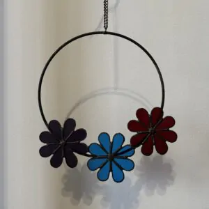 Glas in lood hanger: een ring met daaraan 3 bloemen. In paars, blauw en rood.