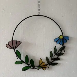 Glas in lood hanger: een metalen ring met daarin 3 soorten bloemen en 2 takjes.