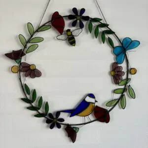 Glas in lood hanger: een ring met daarop bloemen en een vogel.