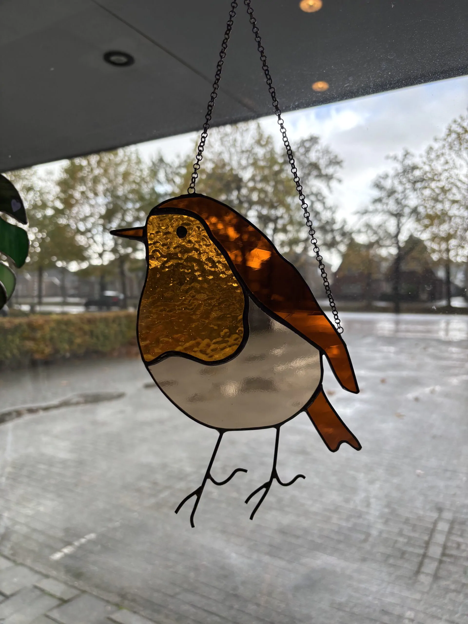 Glas in lood hanger: een roodborstje gemaakt met transparant glas.