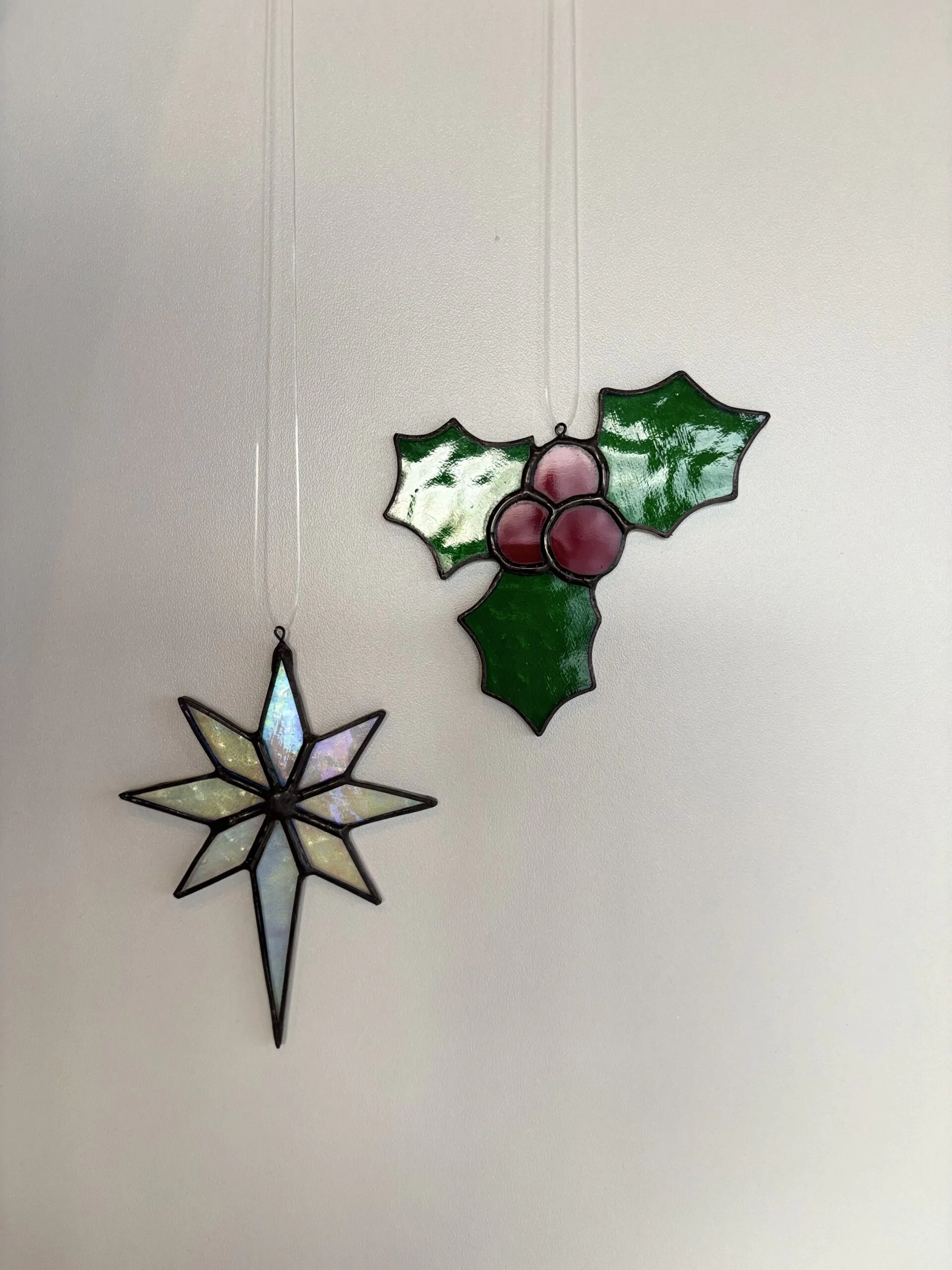 Tiffany glaskunst: Sfeerfoto hulstbladeren met bessen en een kerstster.