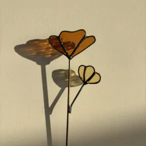 Tiffany glaskunst: een amber kleur 3-bloemblad met een licht geel bloemetje op steel.