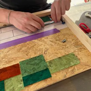 Cursist aan het werk aan een glas-in-lood raampje